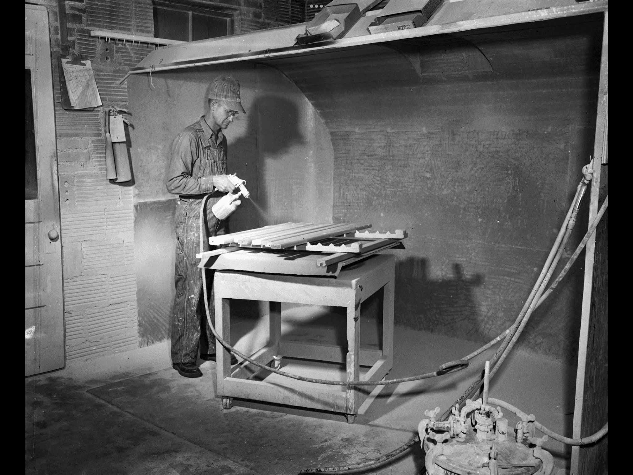 Worker painting window coverings